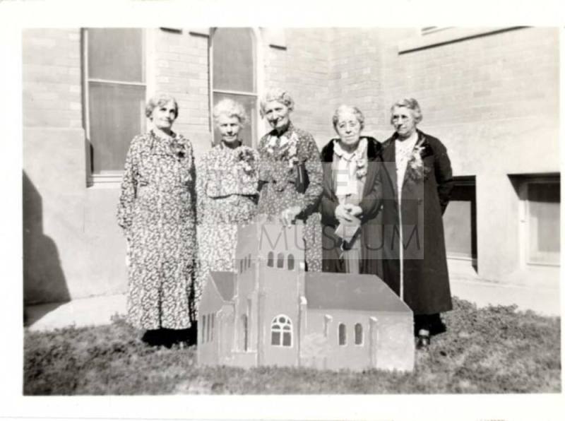 Laird women posing with model of a church