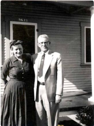 Photo of Ann and Frank Raymond in front of a house