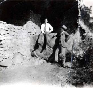 Frank Raymond and Man Standing by a Stone Wall