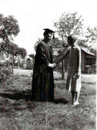 Frank Raymond in Cap and Gown Shaking Minnie's Hand