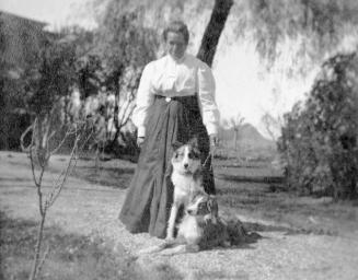 Susanna Petersen with dogs in yard, Tempe Butte visible in distance.