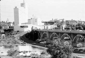 Looking south across Salt River at Hayden Flour Mill, Mill Avenue bridge on right, and roadway through riverbed in lower center