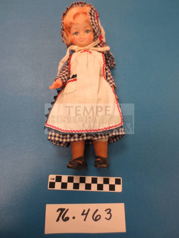 Doll wearing housedress with apron and bonnet