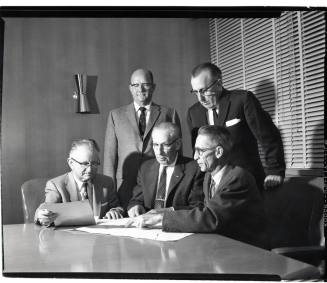 Group of Five Men Looking at Papers