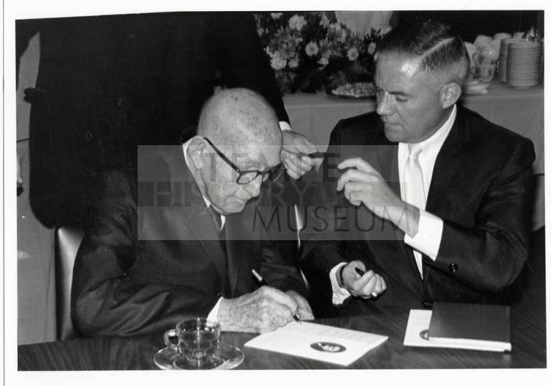 Senator Carl Hayden and another man sign a document