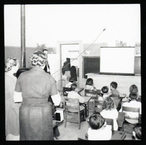 Teachers and children in primary classroom
