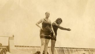 Two women in swim suits stand near Granite Reef Dam