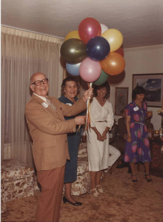 Howard Pyle Holding Balloons at Party