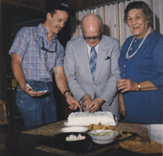 Howard Pyle, Lucile, and Grandson Cut Cake