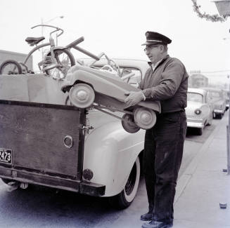 Uniformed Man Holding a Toy Car on Mill Avenue