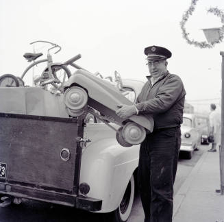 Uniformed Man Holding a Toy Car on Mill Avenue