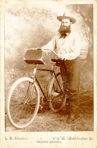 Dr. Fenn J Hart posing next to a bicycle in Phoenix, Arizona