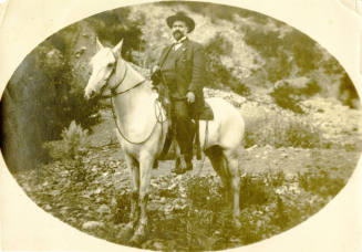 Dr. Fenn J Hart atop white horse in the desert