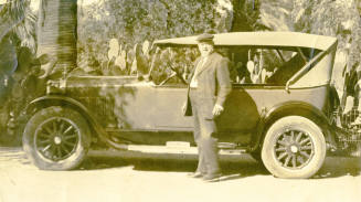 Dr. Fenn J Hart standing outside in front of his Dodge