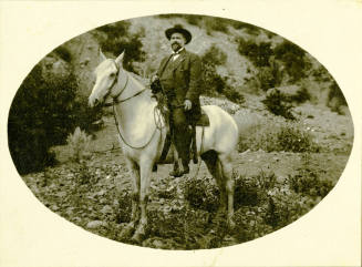 Dr. Fenn J Hart atop a white horse in open canyon