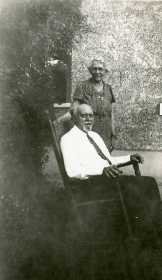 Dr. Fenn J Hart sitting in rocking chair beside his wife Rosa Brown Hart