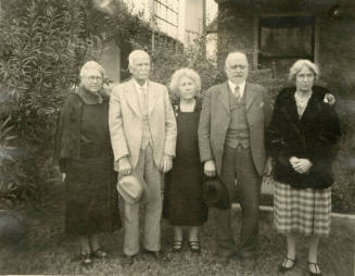 Group photo of Dr. Fenn J Hart standing outside an unknown home with his wife, Rosa Brown Hart, his brother-in-law Thomas Knight, and two unknown females