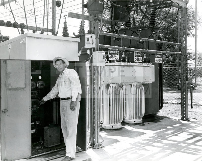 Man Standing by Electric Panel at Power Plant