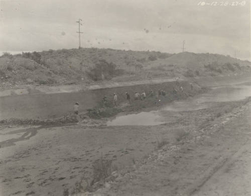 Photo- men repairing lining of Great Eastern Canal in front of desert wash