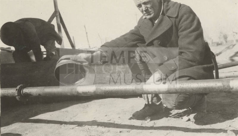 Photo Worker examining a pipe