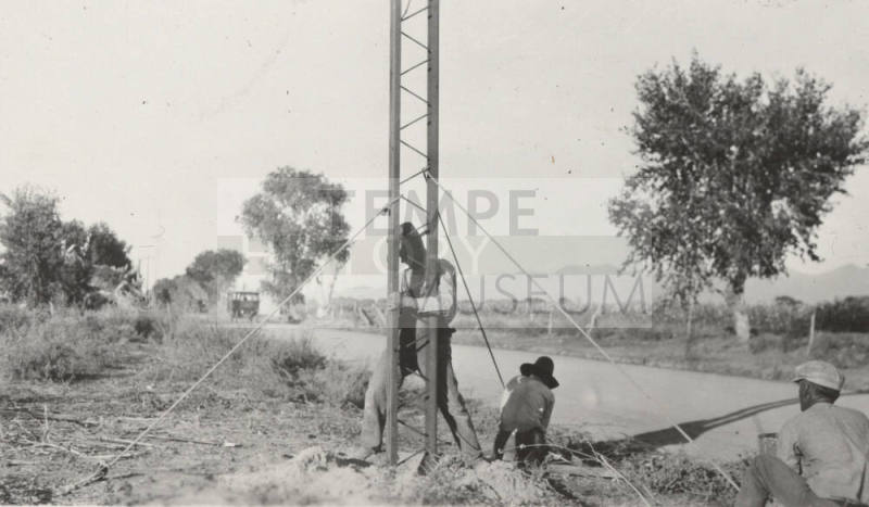 Workers setting power line steel pole
