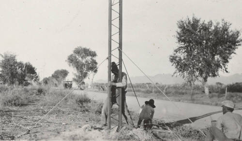 Workers setting power line steel pole