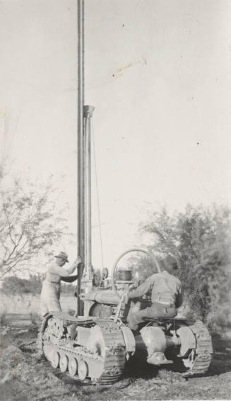 Photo-Men operating a pole hole digging machine