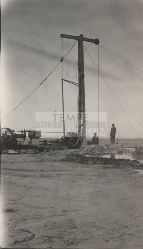 Photo-View of two men operating a drilling rig in the desert