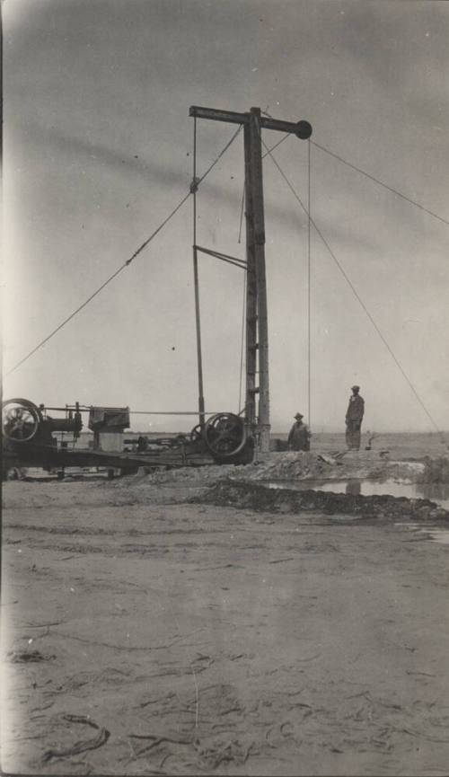 Photo-View of two men operating a drilling rig in the desert