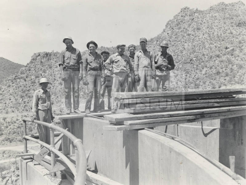 Photo- Eight workers standing on top of Bartlett Dam