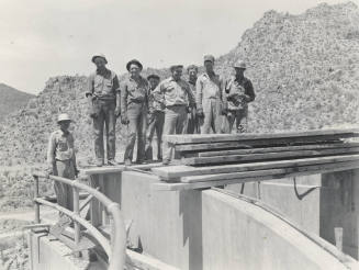 Photo- Eight workers standing on top of Bartlett Dam