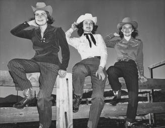 Three Glamorous Cowgirls Posing on a Fence