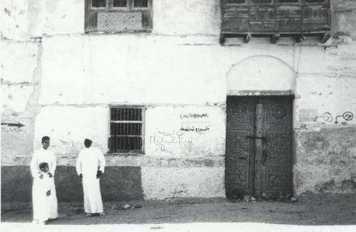 Carved Door with Three People Dressed in White