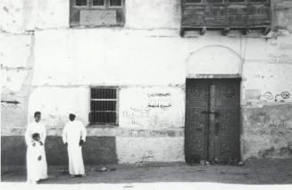 Carved Door with Three People Dressed in White