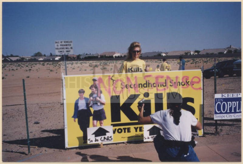 Laura Rocha and a Reporter/Photographer with Defaced Proposition 200 Sign.