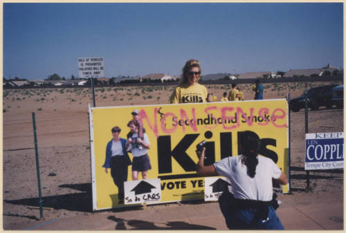 Laura Rocha and a Reporter/Photographer with Defaced Proposition 200 Sign.