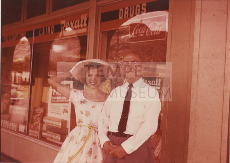 Connie Null Zimmerman and William E. Laird in front of the Laird Pharmacy, 1956