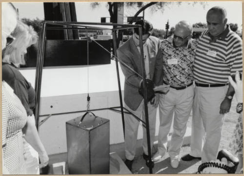 Photo of Mayor Neil Giuliano Lowering Time Capsule Behind Tempe Historical Museum Sign with Councilmembers.