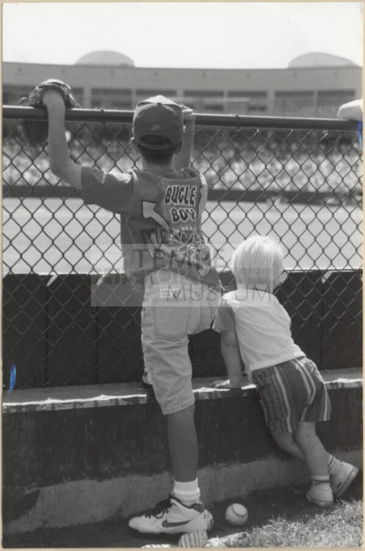 Photo of Two Children in Grassy Spectator Area at Tempe Diablo Stadium.