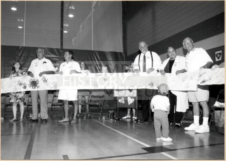 Photo of Stand for Children event speakers holding handprint banner.