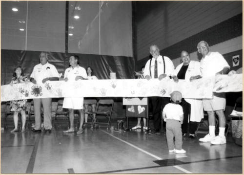 Photo of Stand for Children event speakers holding handprint banner.