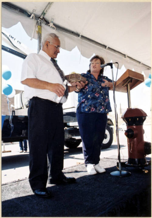 Color photograph of water treatment plant dedication where Johnny Martinez receives present from woman.