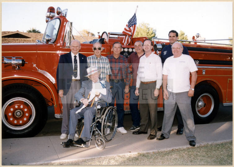 Color photograph of group of people posing in front of fire engine at the dedication of Hollis family park