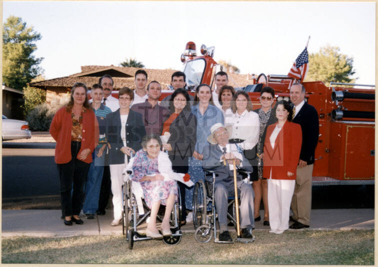 Color photograph of Hollises by fire engine with large group at Hollis Family Park dedication