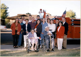 Color photograph of Hollises by fire engine with large group at Hollis Family Park dedication