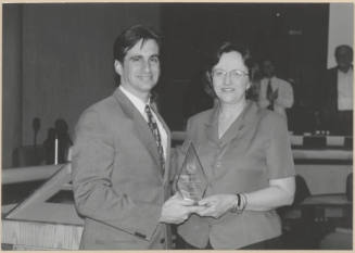 Photograph of Mayor Niel Giulano and woman holding glass trophy