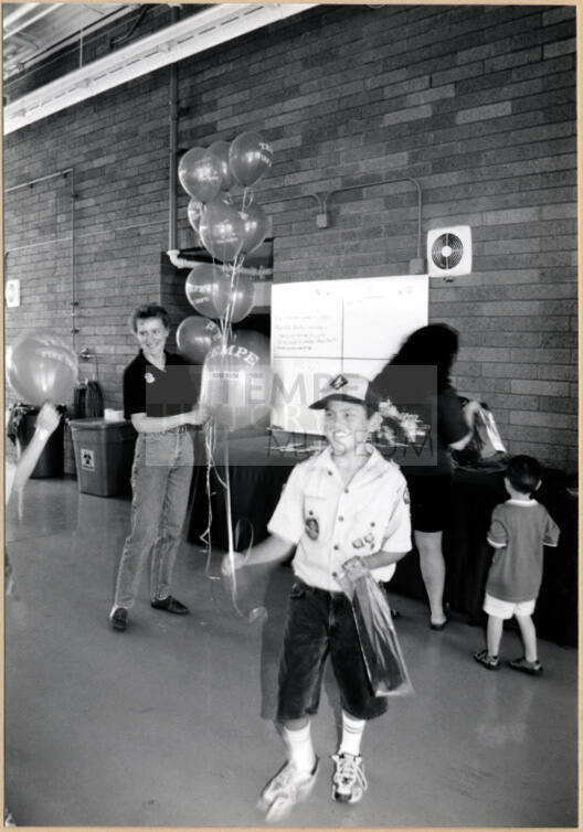 Black and white photograph of Cub Scout holding balloons at Fire Prevention Day