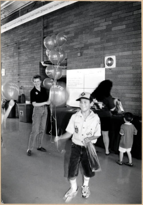 Black and white photograph of Cub Scout holding balloons at Fire Prevention Day