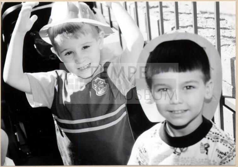Black and white photograph of children with fire hats at Fire Prevention Day