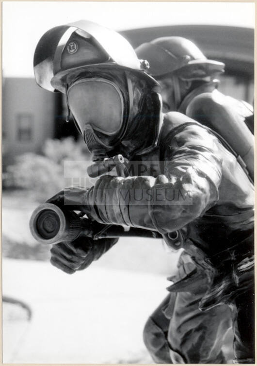 Black and white photograph of fire fighter statue at the dedication of Apache Blvd. Fire Station